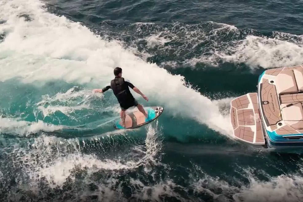 A man is wakesurfing behind a boat.