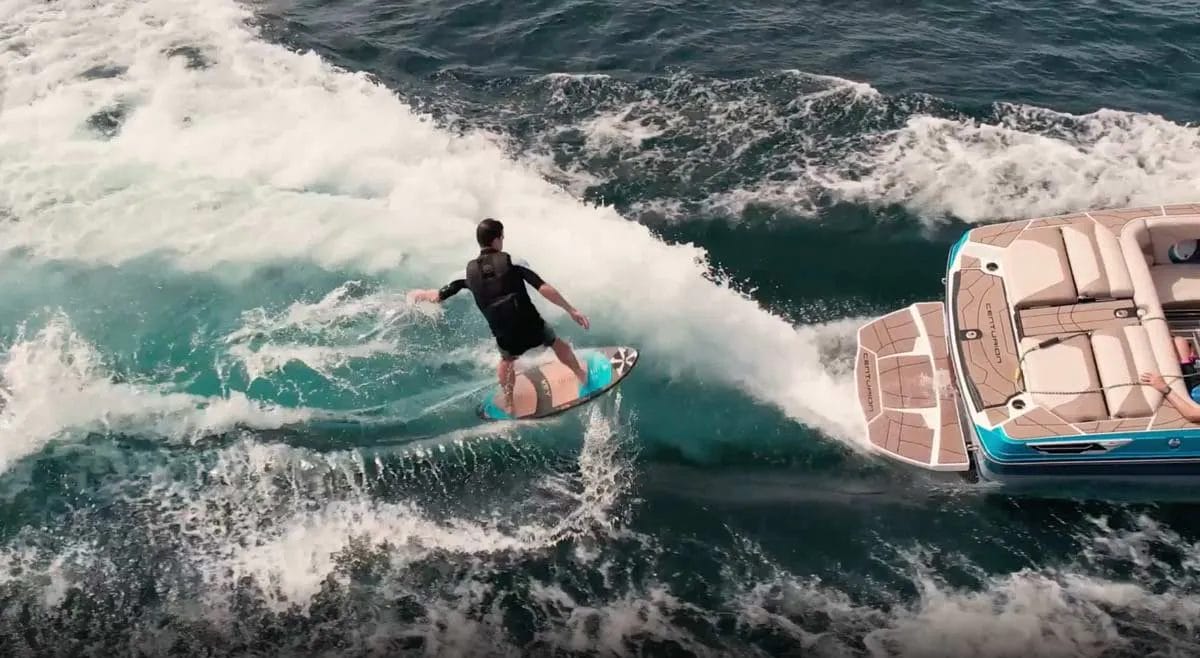 A man is wakesurfing behind a boat.