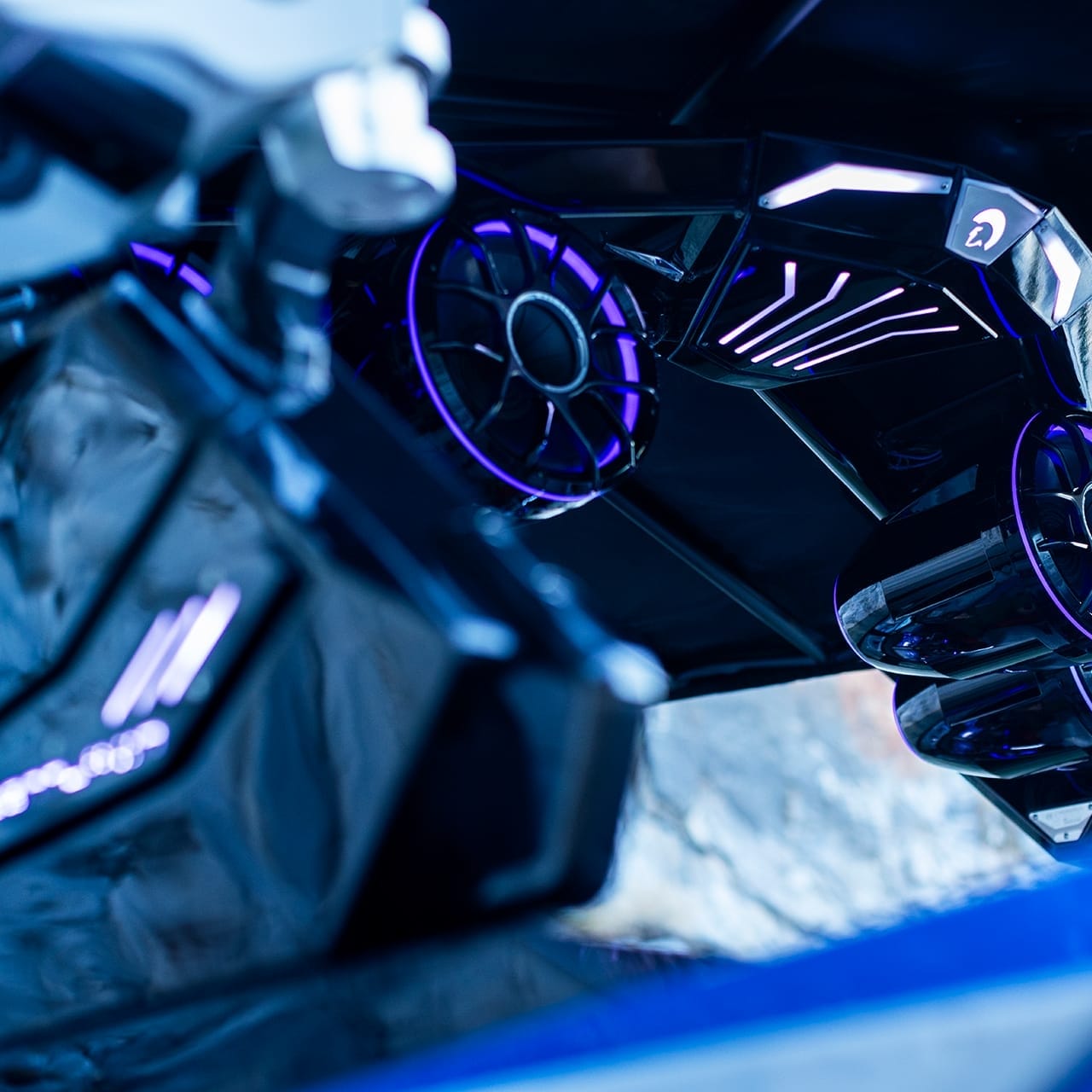 Close-up of the Centurion Ri230's undercarriage with illuminated circular components and glowing accents in shades of blue and purple, showcasing its futuristic design.