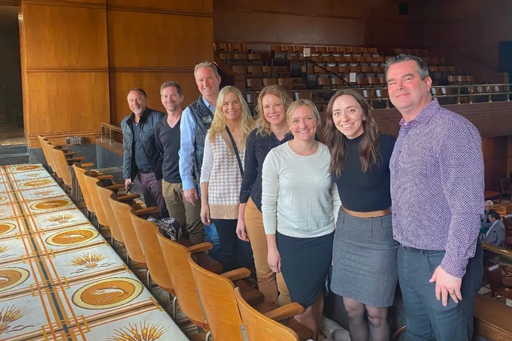 A group of people posing for a photo in an auditorium.