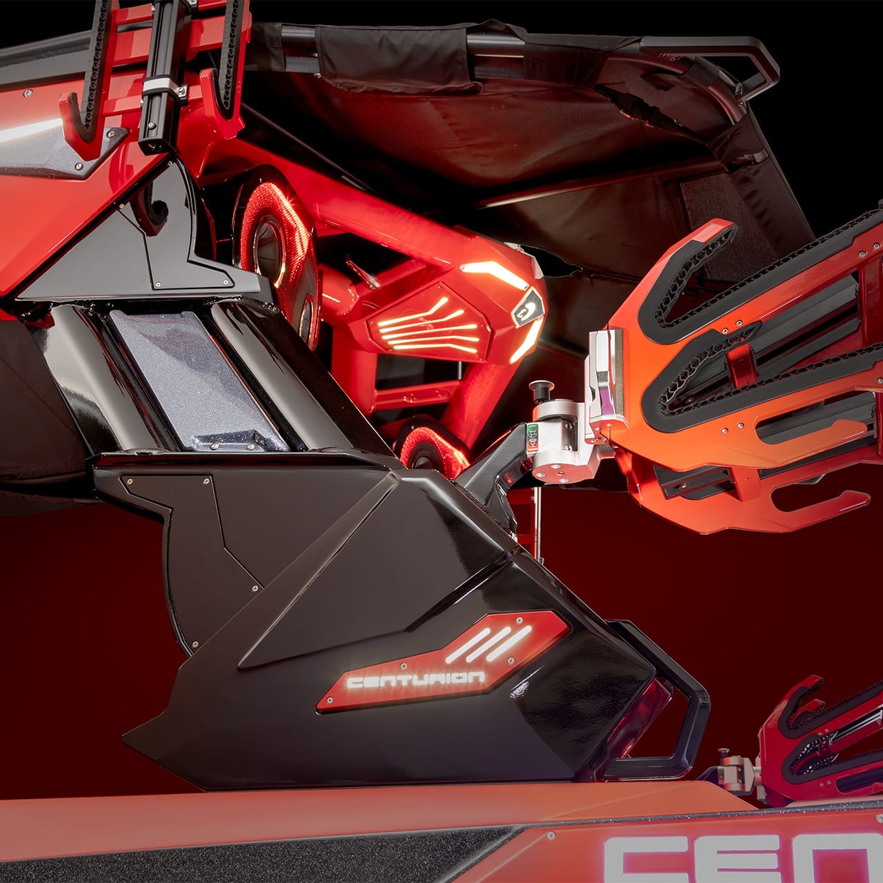 Close-up of the Centurion Ri265, a futuristic red and black gaming rig with LED accents and an angular design.