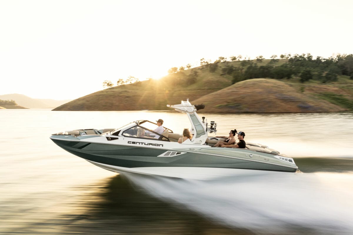 A group of people wakesurfing on a wakeboat.