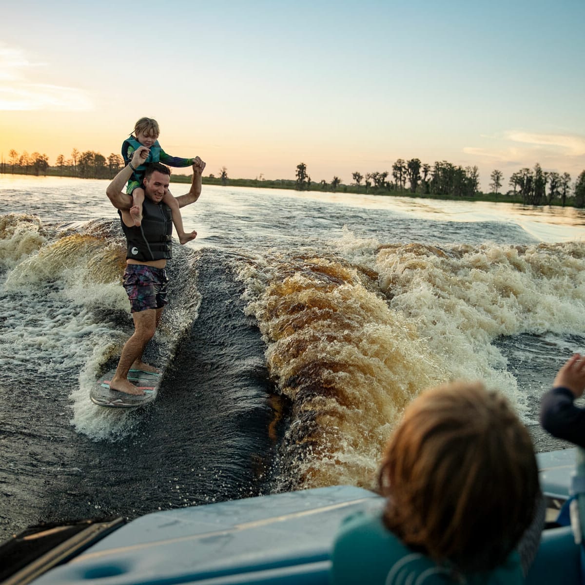 A group riding a wakesurf boat.