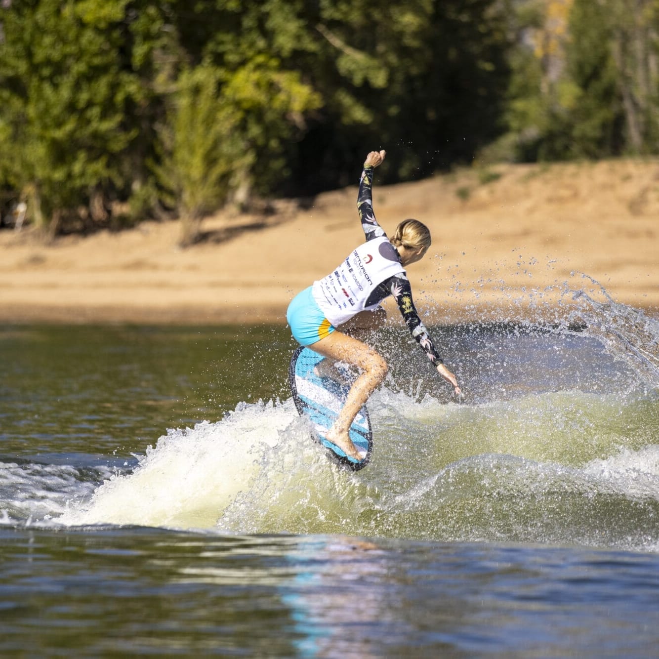 A woman is riding a wave on a surfboard.