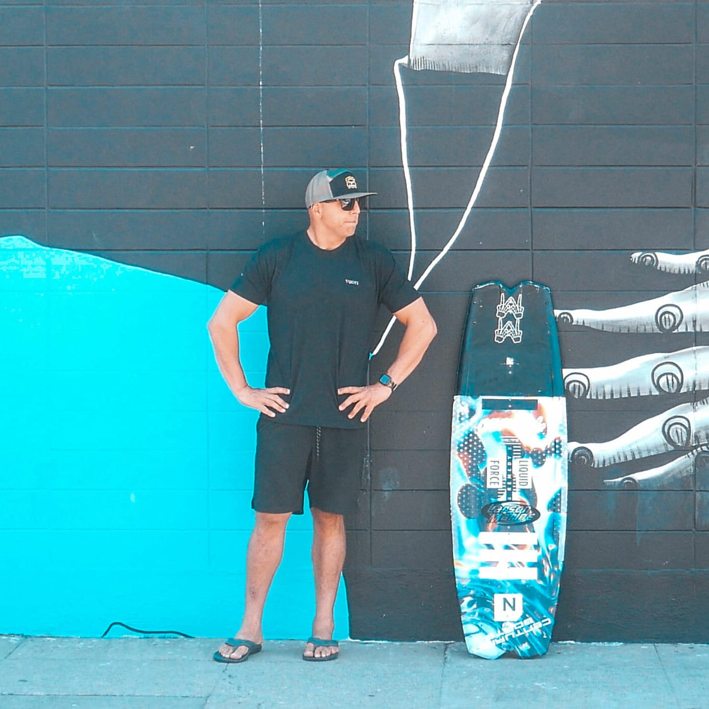 A man leaning against a surfboard.