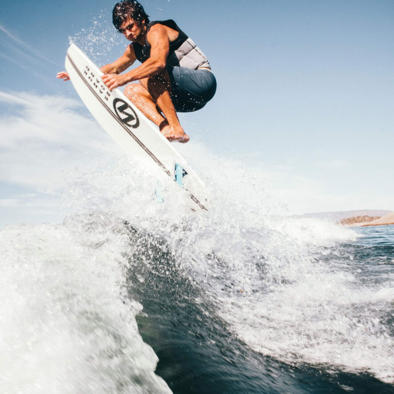 A man wakesurfing behind a boat.