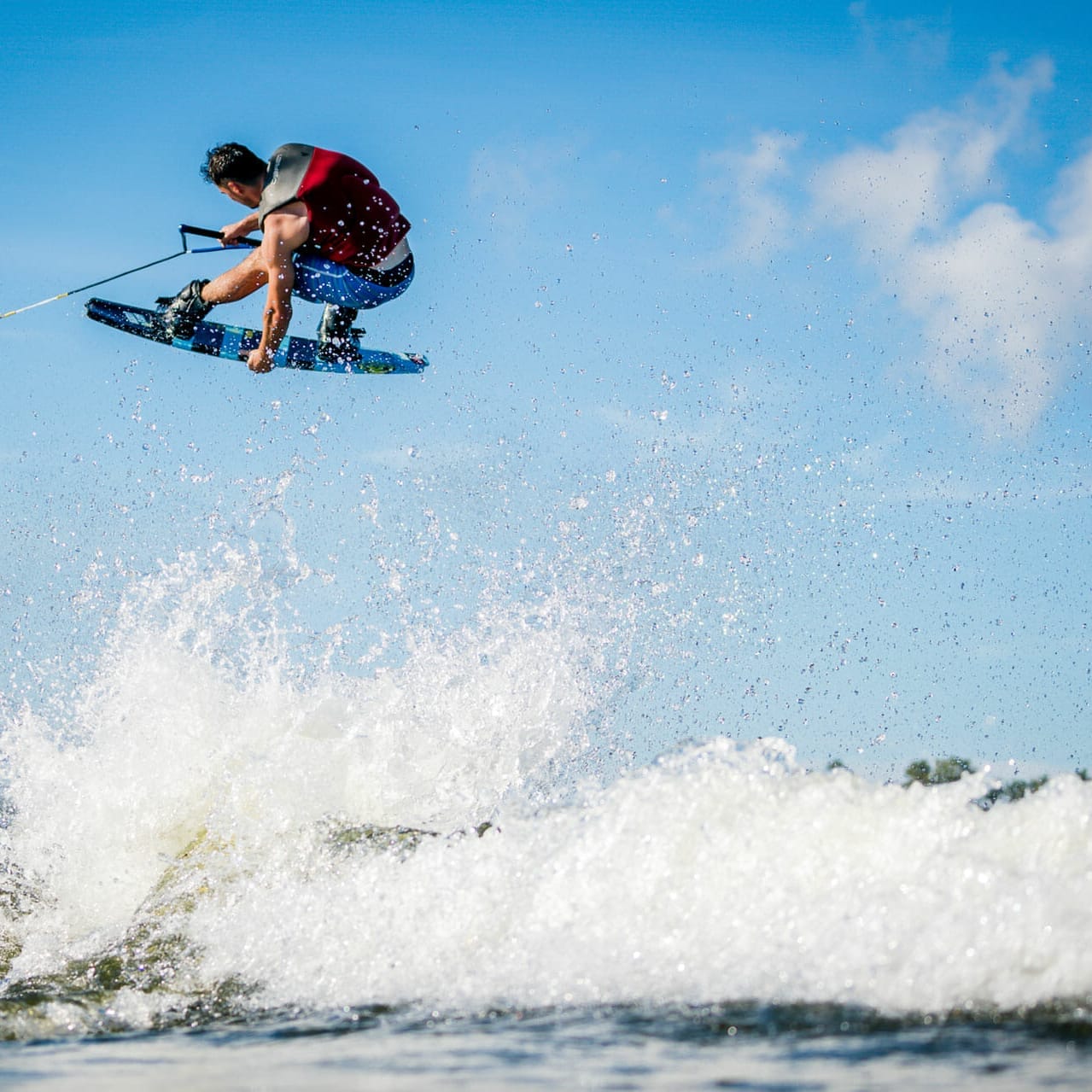 A man is wakesurfing behind a boat.