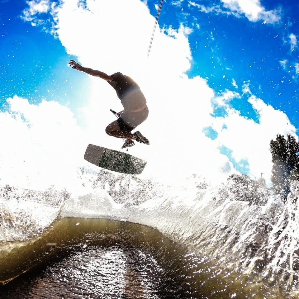 A person performing a trick on a wakesurf board.