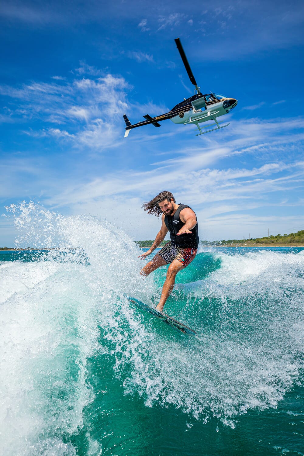 A man is wakesurfing behind a boat.