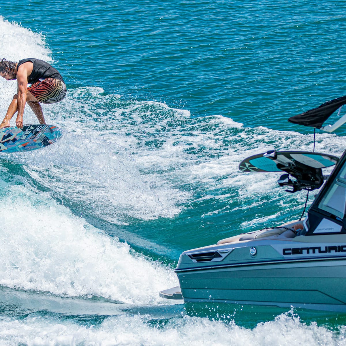 A man is wakesurfing behind a boat.