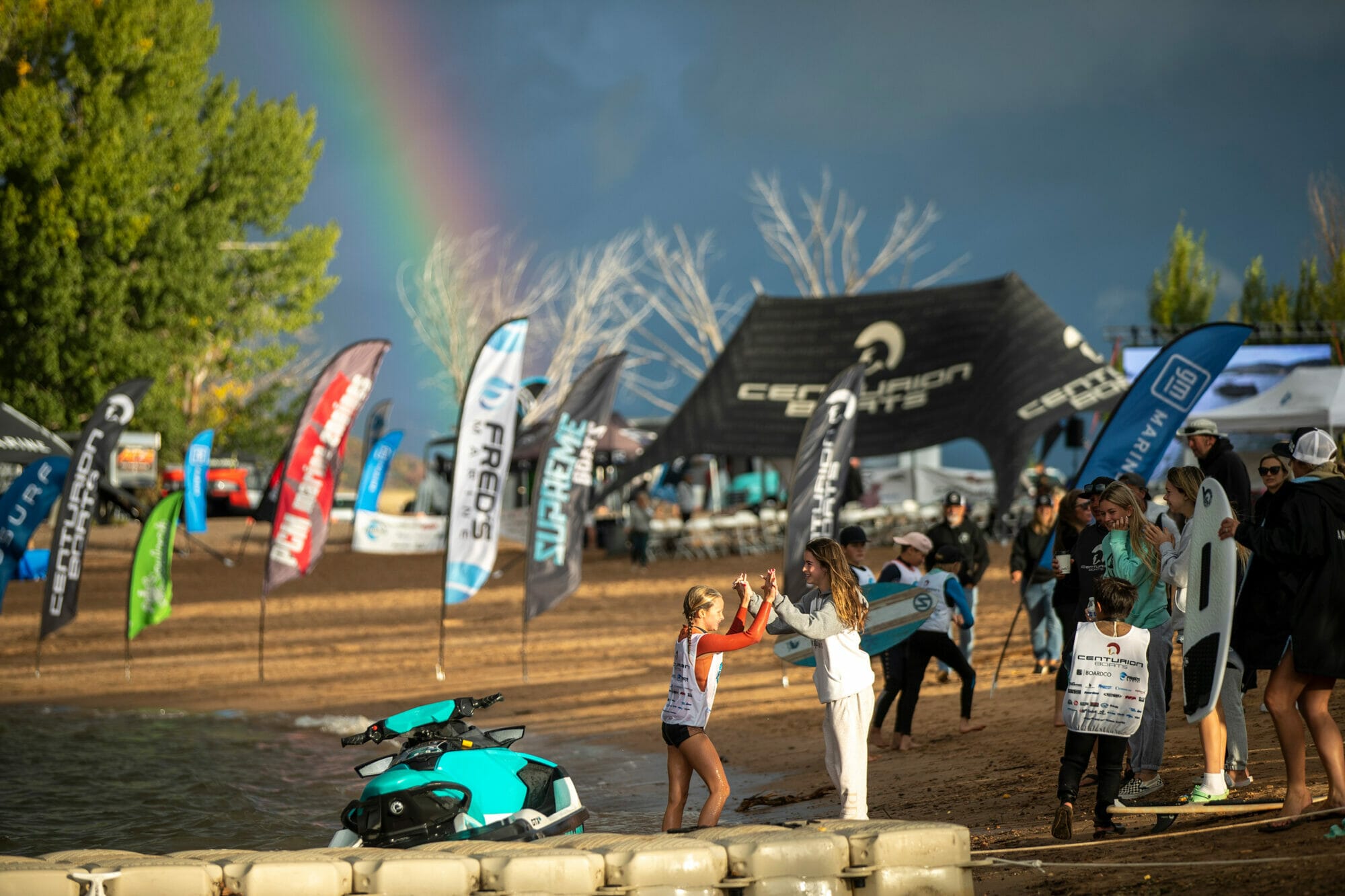 A group of people on a beach with a wakesurf board.