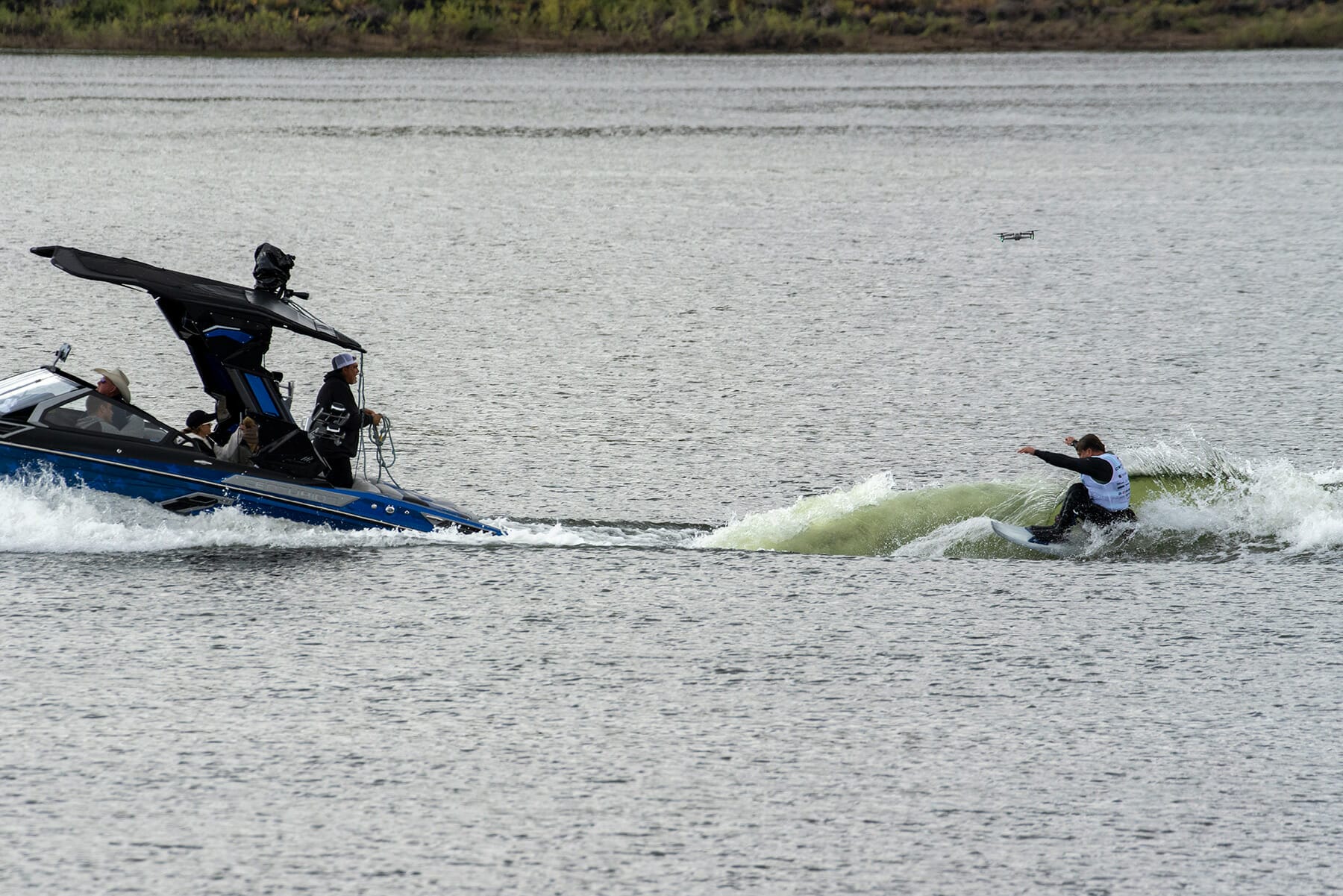 A person riding a surfboard on a boat in a body of water.