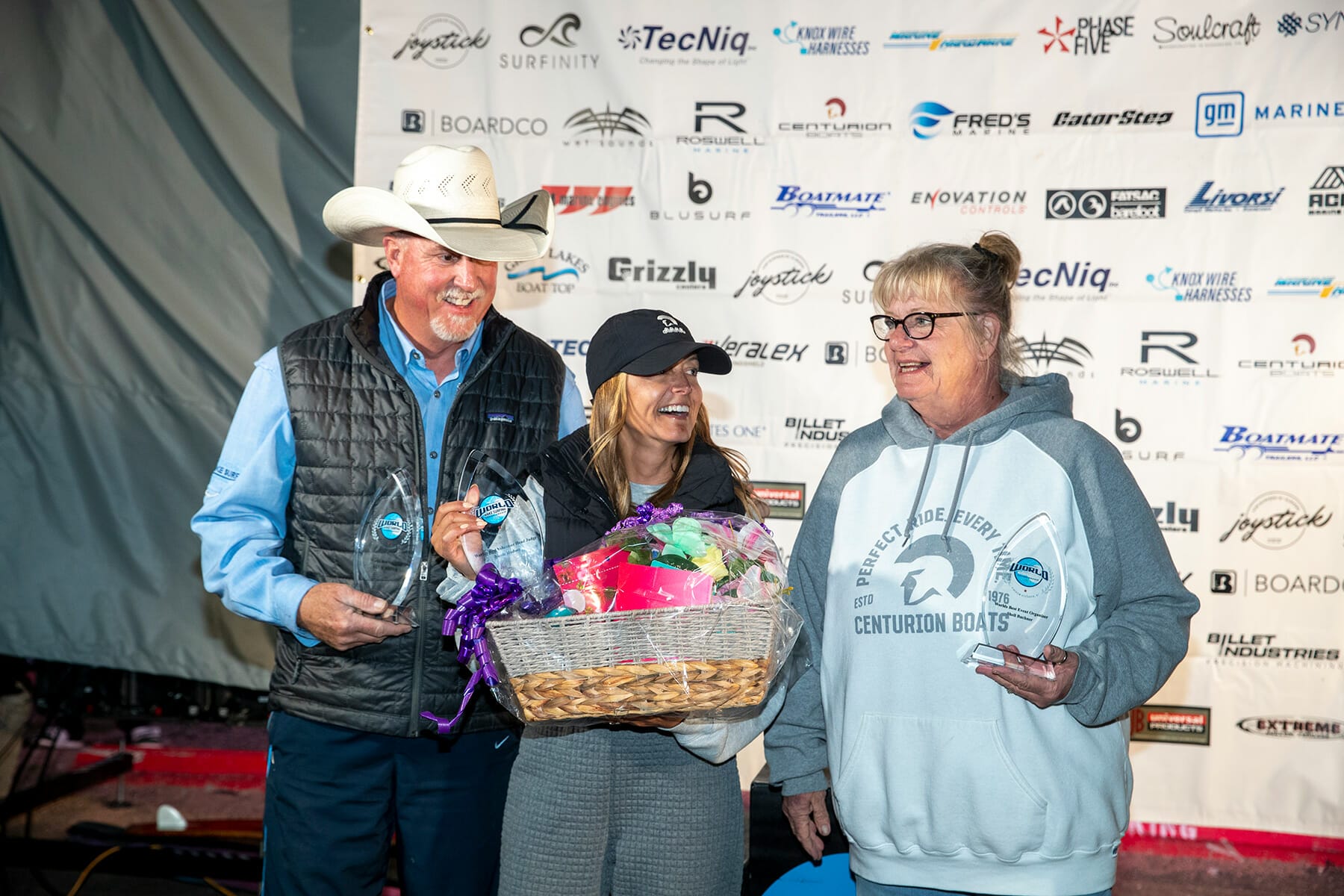 Three people holding trophies at the 2024 WWSC Day 2 Recap.