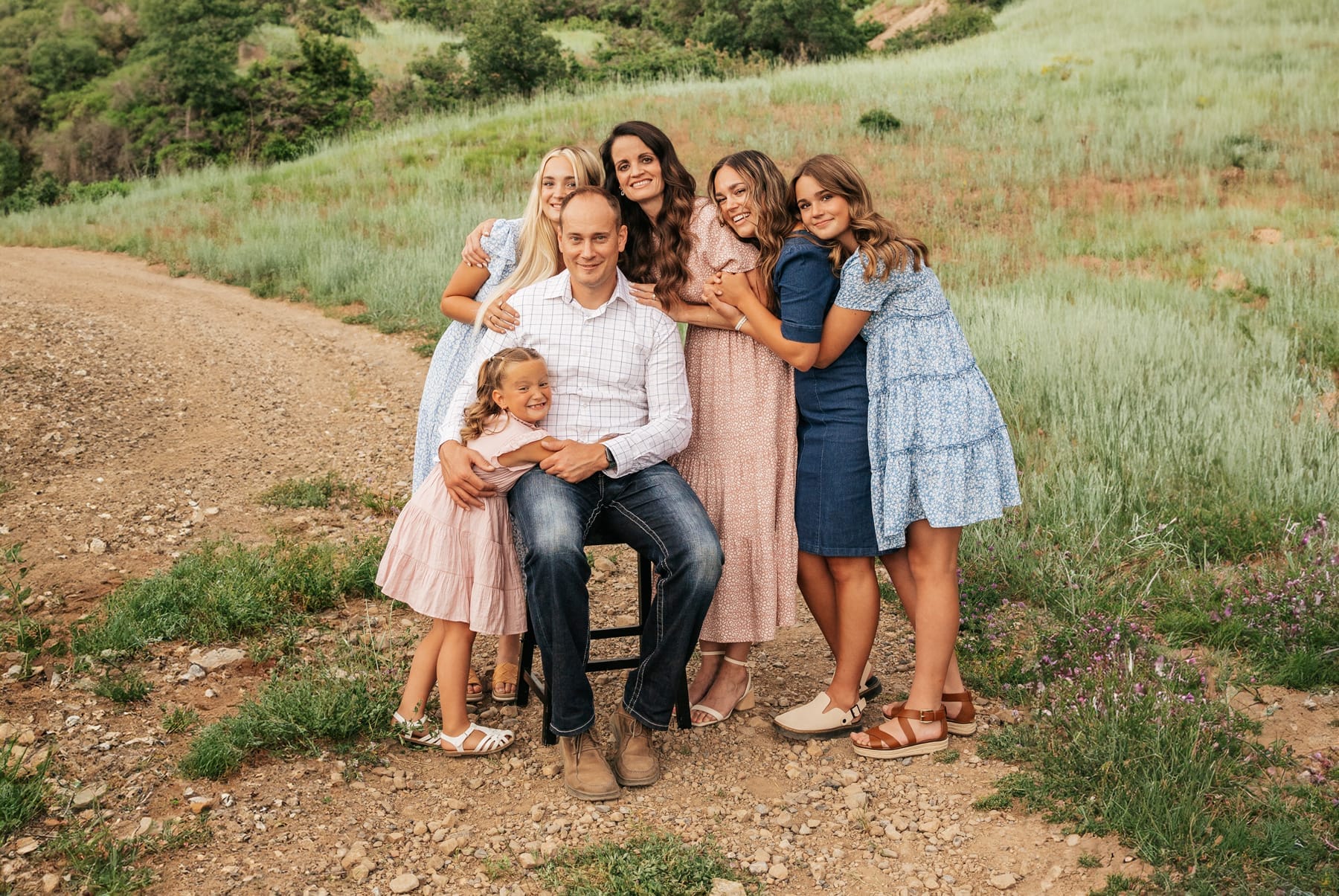 A family posing for a photo on a dirt road.