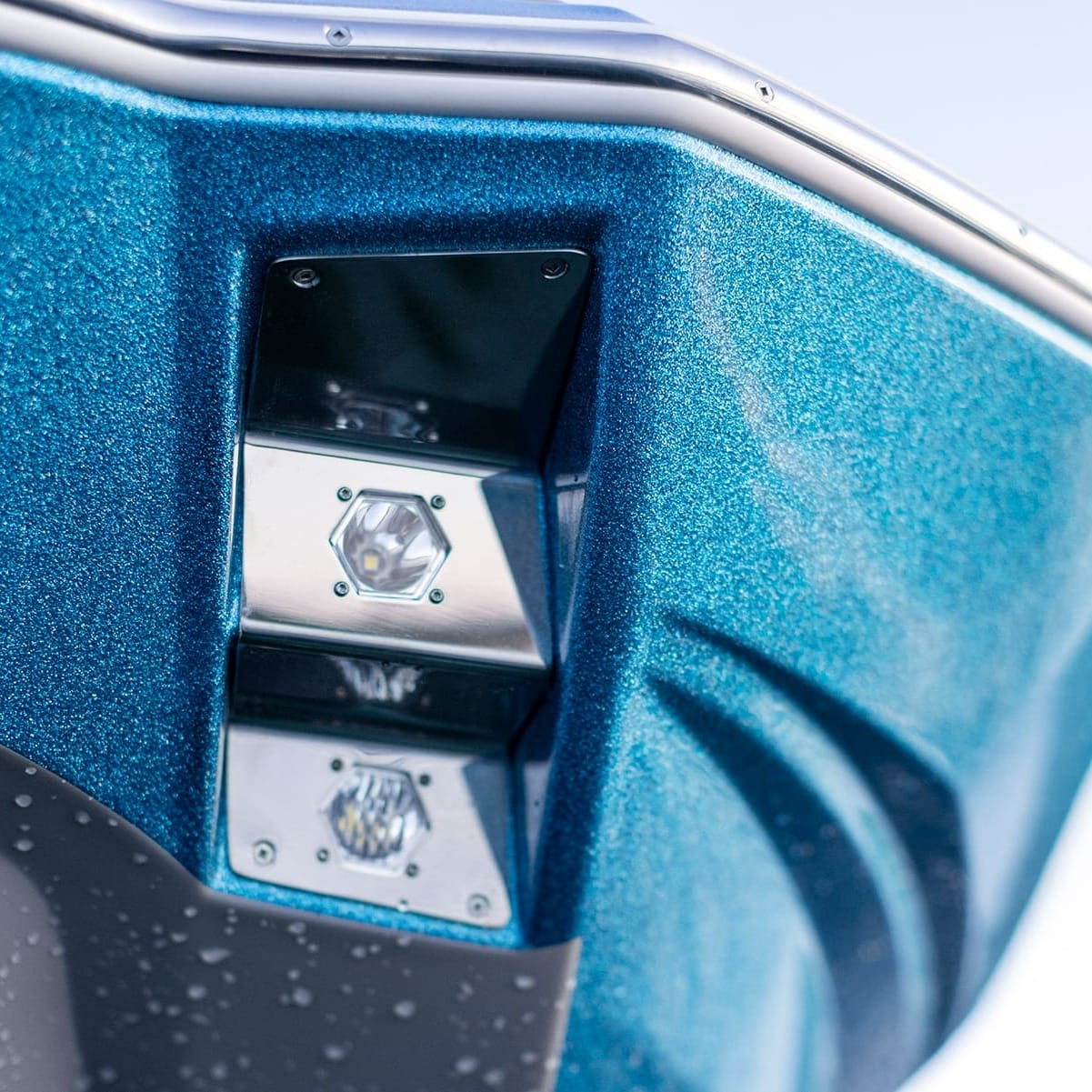 Close-up view of a blue-painted Centurion Fe22's stern featuring two integrated LED lights with chrome trim.