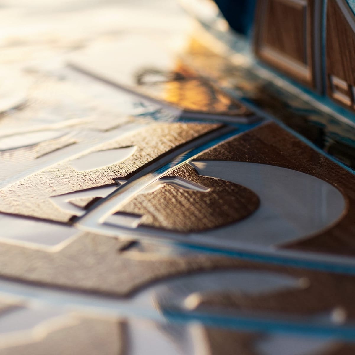 Close-up image of a detailed wooden carving, featuring abstract patterns and lines, illuminated by soft natural light that gently highlights the craftsmanship. The design evokes the timeless strength of a Centurion Fe22 helmet with its intricate details and bold aesthetics.