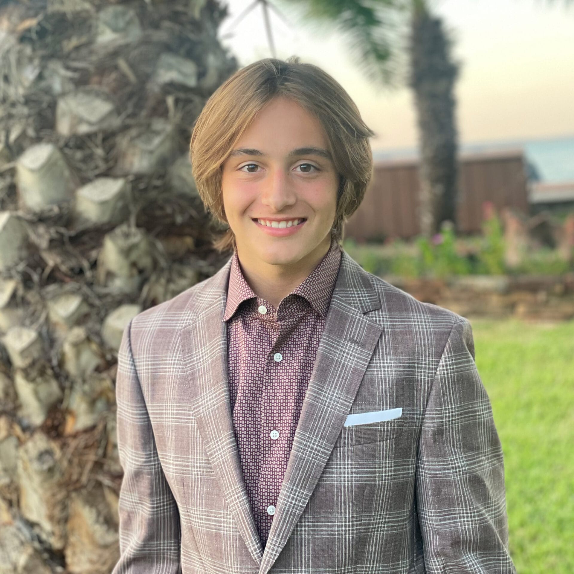 Wake Surfer Evan Hudson, sporting a stylish suit, showcases his impressive skills on the water.