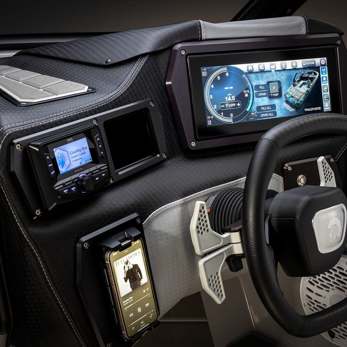 The image shows a high-tech vehicle dashboard with a steering wheel, digital display screens, and various controls and buttons, including a phone dock.