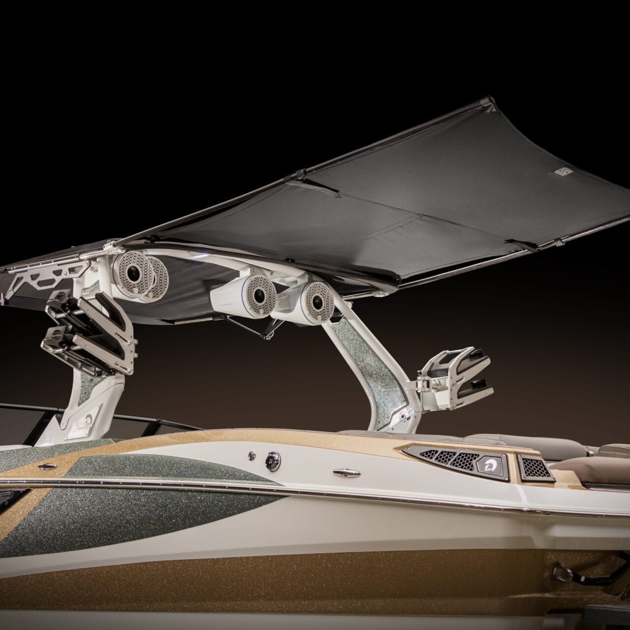 A close-up view of a boat with an extended canopy and multiple speakers attached. The boat features a sleek design with metallic accents.