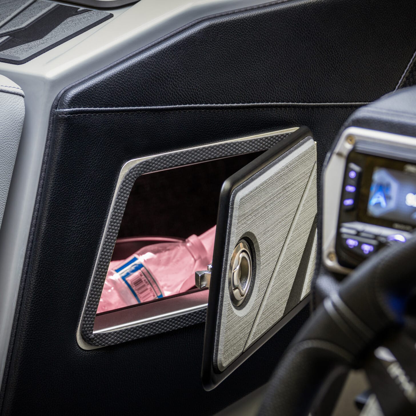 Glove compartment open, containing a pink bag and a folded paper. Black and gray dashboard visible.