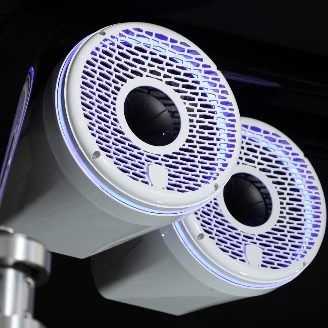 Two white, cylindrical speakers with mesh fronts and blue LED lights mounted on a ceiling bracket.