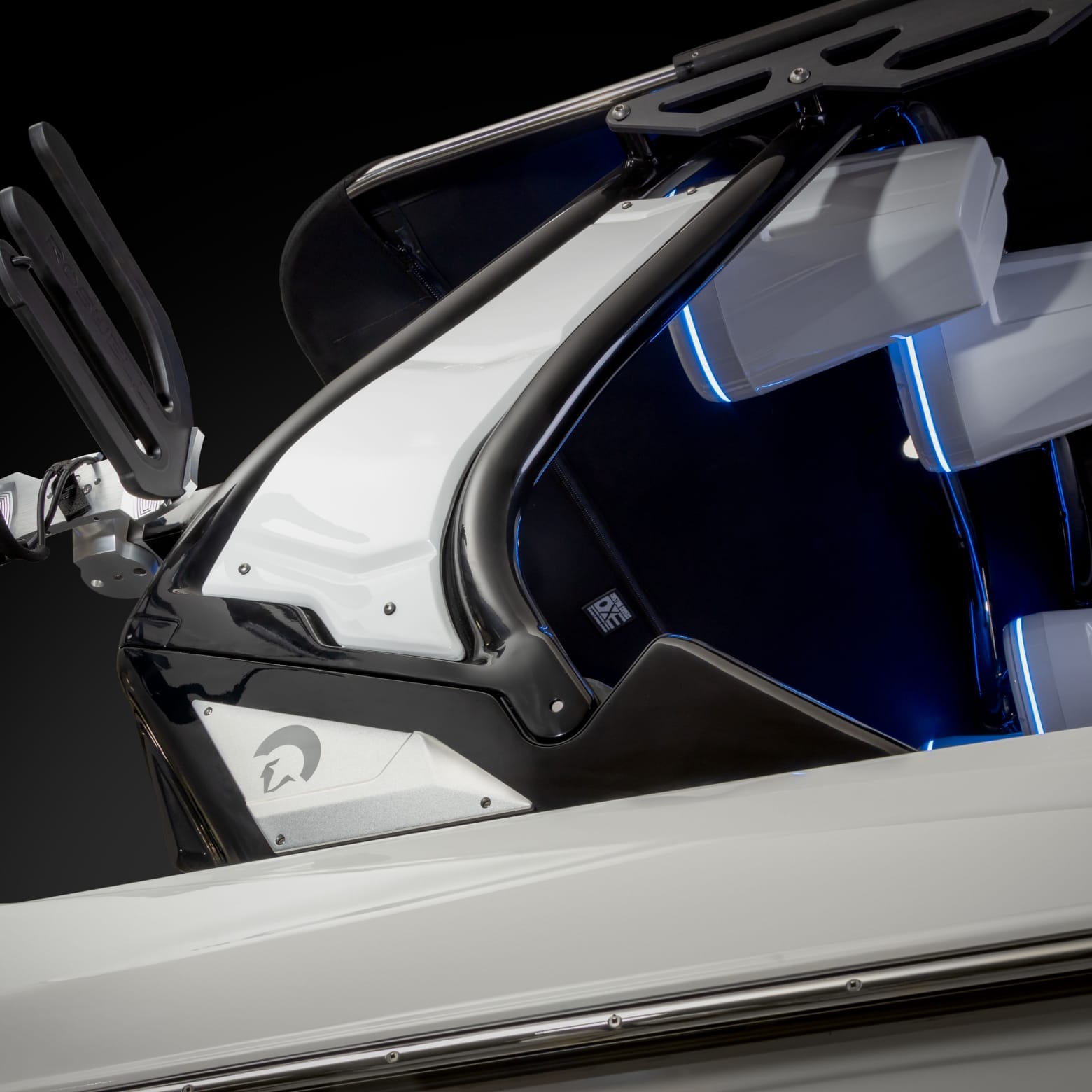 Close-up of a sleek boat with a glossy black and white body and blue interior lighting.